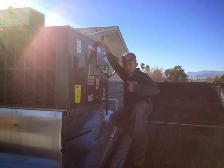 HVAC technician performing HVAC Inspection on a rooftop unit in Lindstrom